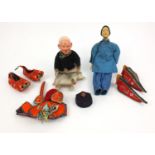 Two oriental Chinese wooden carved dolls with assorted silk costumes, the larger 28cm high