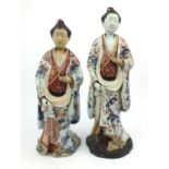 Large pair of Japanese Imari patterned porcelain figures with hand painted floral robes - one on a