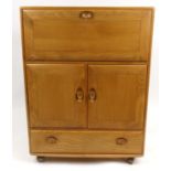 Ercol Windsor light elm drinks cabinet fitted with a fall above two cupboard doors and a drawer,