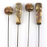 Four Japanese Satsuma pottery hat pins painted with flowers, figures and ladies, each 30cm long