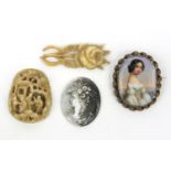 Two oriental carved ivory panels, porcelain maiden brooch and one other maiden head panel