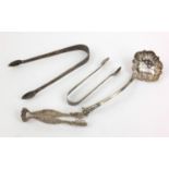 Silver items comprising Victorian sifting spoon, Georgian sugar tongs and one other pair of sugar