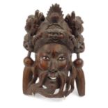 Oriental Chinese hardwood wall mask carved with dragons, beaded glass eyes and ivory teeth, 27cm