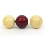 Three ivory snooker balls, the largest 4.5cm diameter