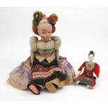 Oriental wooden doll with fabric clothes, together with a larger continental doll, the larger 59cm