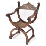 Carved wooden X-framed chair with face finials, 85cm high