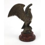 Cast metal model of an eagle raised on a red marble base, 26cm high including the base