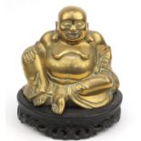 Oriental Chinese brass Buddha raised on a wooden base, 25cm high