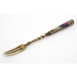 Continental unmarked silver fork the handle enamelled with classical scenes of figures, 17cms long