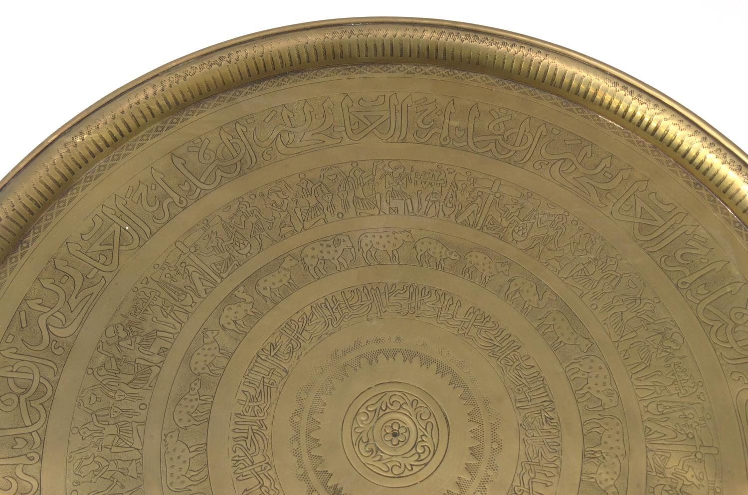 Middle Eastern brass tray topped circular occasional table decorated with figures and script, the - Image 9 of 9