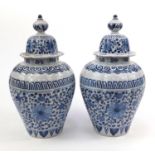 Pair of Dutch Delft pottery vases and covers hand painted with flowers, initials to base, 39cms high