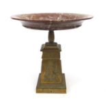 Large red variegated marble topped tazza mounted on a tapered brass column decorated in relief