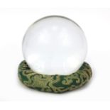 Large fortune teller's crystal ball on an oriental Chinese dragon green cloth stand, the crystal