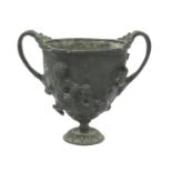 Antique bronze urn embossed with classical scenes, the interior with applied phallic symbol, 14cm