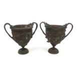 Pair of brass twin handled urns both embossed with classical scenes, both with liners, each 16cm