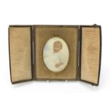 Oval portrait miniature of a young child, housed in a gilt metal frame and a velvet lined leather