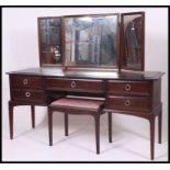 A Stag ' Minstrel ' mahogany dressing table raised on squared legs with a series of drawers beneath