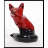 A Royal Doulton Flambe figure of a seated fox, bold black and red colouring,