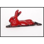 A Royal Doulton Flambe figure of a lying rabbit, bold black and red colouring,