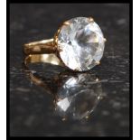 A stunning 18ct yellow gold dress ring with inset large round cut white sapphire being claw mounted