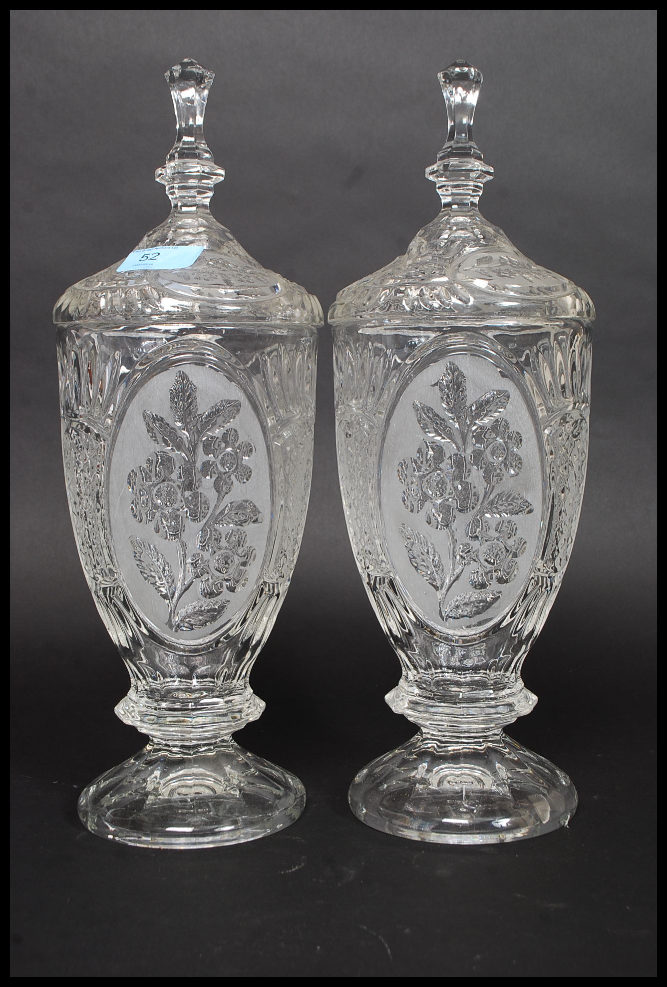 A pair of 20th century cut glass tall biscuit barrels, each to lids having finials tops.