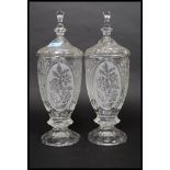 A pair of 20th century cut glass tall biscuit barrels, each to lids having finials tops.