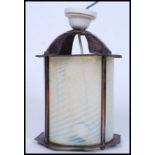 A vintage 20th century Arts & Crafts style copper lantern with coloured glass inset cylinder shade.