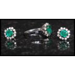 An 18ct white gold, emerald and diamond ring and earring set.