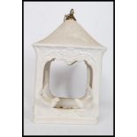 A large ceramic bird feeder of lantern shape embellished with birds to the sides having chain atop.