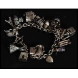 A silver 800 marked continental charm bracelet adorned with 20+ charms to include dancer, grapes,