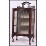 An Edwardian mahogany leaded and coloured glass bow front display cabinet.