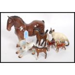 A collection of Beswick style figurines to include horses, Siamese cat, lamb,