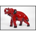 A Royal Doulton Flambe figure of an elephant, bold black and red colouring,