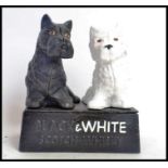 A reproduction cast iron Black & White Whiskey statue figure, depicting the famous Terrier dogs.