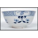 An 18th century blue and white Delft bowl with flower head decoration and geometric border 1765