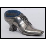 A silver plated pin cushion in the form of a shoe with baize upper.