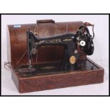 A vintage cased early 20th century Singer sewing machine with manual and accessories complete with