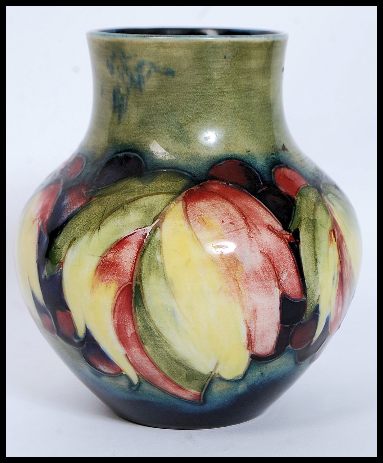 A 1930's  ( c1928-1949 ) William Moorcroft tubeline baluster vase in the  berry and leaf pattern