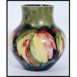 A 1930's  ( c1928-1949 ) William Moorcroft tubeline baluster vase in the  berry and leaf pattern