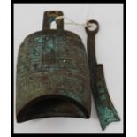 An unusual Chinese cast bronze bell with striker.