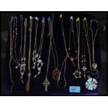 A collection of 14 silver and white metal necklaces and pendants.