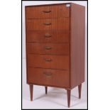 A retro teak effect straight six chest of drawers, raised on stub legs.