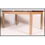 A large contemporary early 21st century oak dining table raised on square legs having a stainless