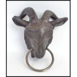 A goat head exterior metal dog leash holder / horse tie. Hand painted.