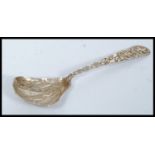 A Chinese silver caddy spoon having decorative shaped bowl with character marks to the handle.