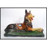 A large mid century plaster figurine of an Alsatian dog in seated position raised on a naturalistic