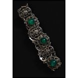 A ladies silver fret worked and green glass stone inset bracelet.