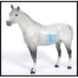 A Beswick ceramic figurine of a grey dappled horse being marked Beswick England in circle motif to