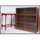 A 1930's oak barleytwist oak side - lamp table together with a similar oak sliding glass library