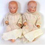 DOLLS: A pair of antique bisque headed composition bodied miniature childrens dolls.